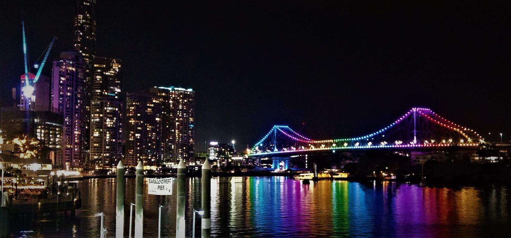 Eagle Street Pier à noite com a vista da Story Bridge iluminada