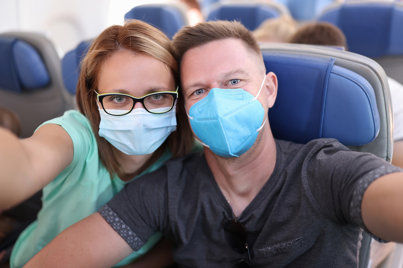 Casal no avião usando máscara