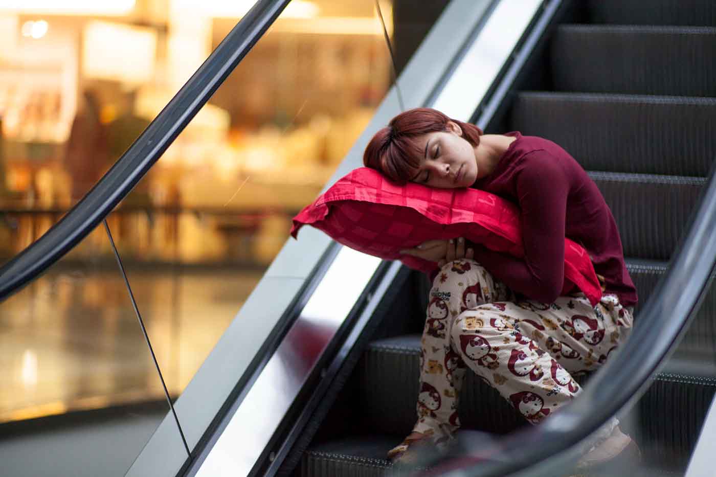 Sintomas do jet lag para quem faz viagens longas de avião moça dormindo na escada do aeroporto